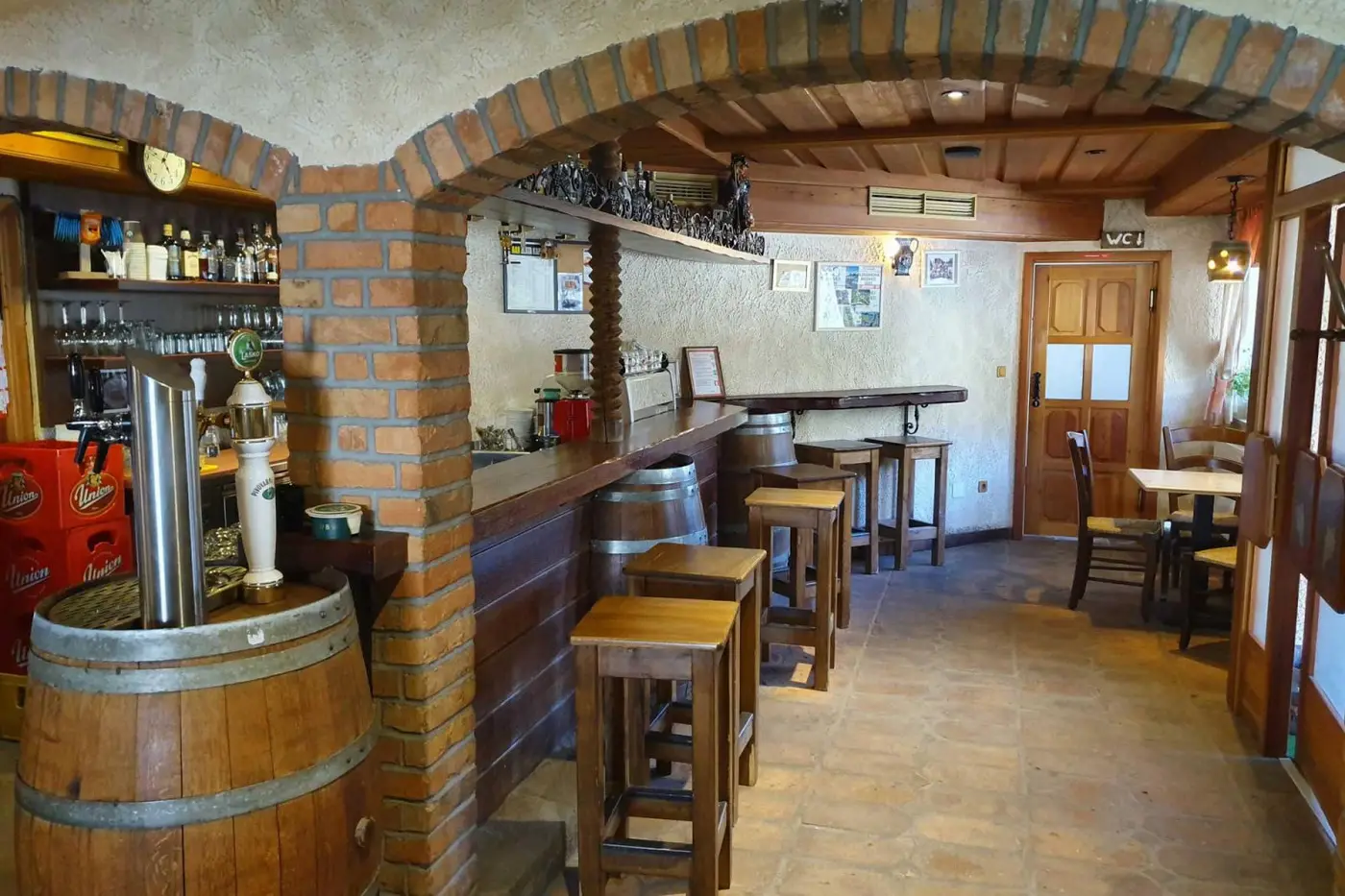 Bar z lesenimi sodi in opečnatimi loki
